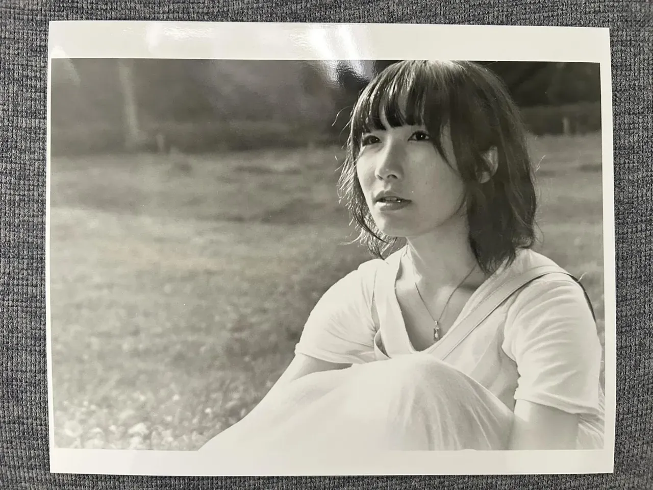 夜間の専門学校時代に槇野翔太さんが撮影した、草の上に座る女性のモノクロポートレート